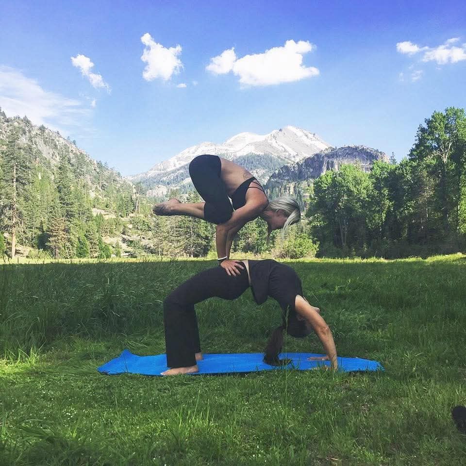 Partner yoga in a mountain meadow